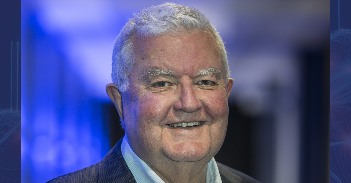 Professor Ian Chubb in a shirt and jacket in front of a blue background