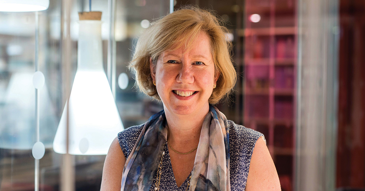 Professor Melissa Brown wearing a scarf in front of a flask light